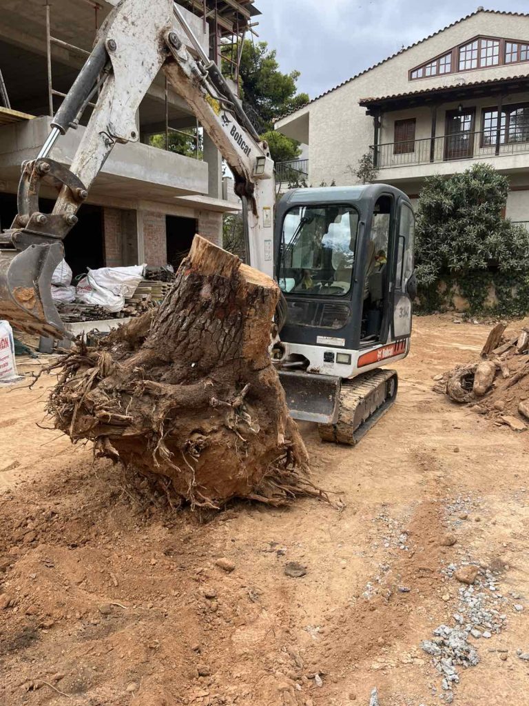 Μίνι εκσκαφέας Bobcat σε εργασία καθαρισμού οικοπέδου
